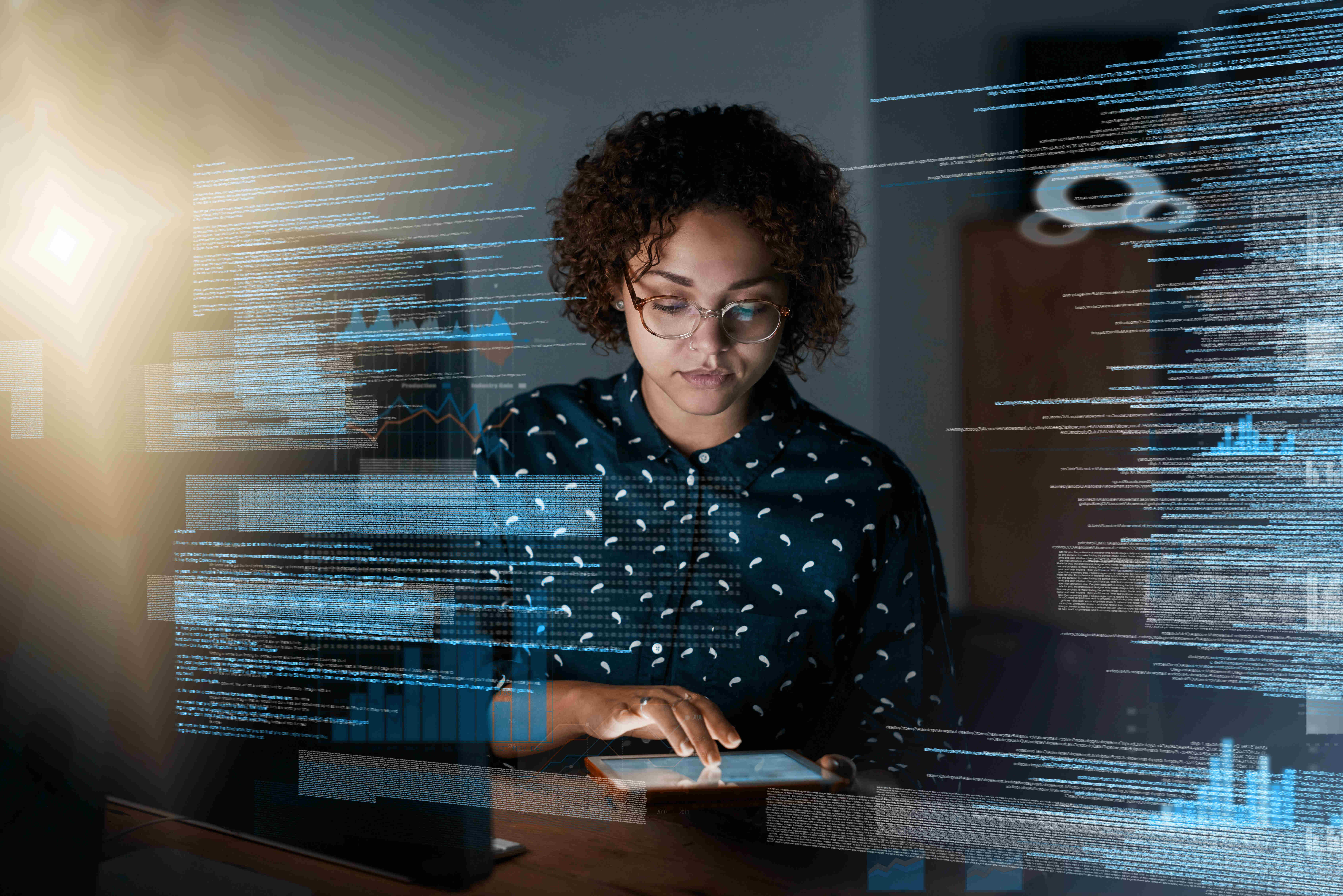 Woman with tablet examining code on large clear wallscreen